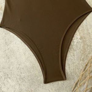 Detail of dark brown matte one-piece swimwear with high-cut design and neat double stitching
