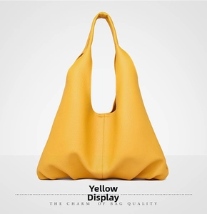 Macro shot of yellow lychee grain leather tote bag with wide shoulder strap texture