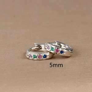 Detail view of 5mm silver huggie earrings with colorful inlaid zircon gemstones