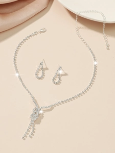 Detailed view of silver rhinestone bridal jewelry set with fringe necklace and drop earrings