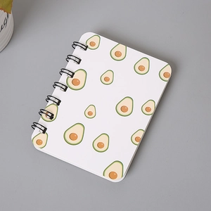 Detail view of A7 pocket notebook with a cute cartoon avocado pattern and black spiral binding