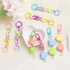 Close-up of colorful heart and star charms with mixed link chains for bag accessories