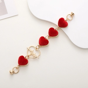 Detail of gold metal phone chain with red velvet hearts and magnetic screw fasteners