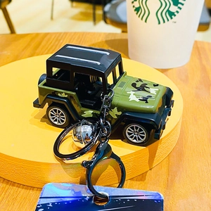 Detail of camouflage Jeep style keychain with metal bell and star pattern tag charm