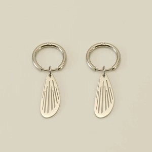 Detail of silver hoop earrings featuring hollow wing charms with brushed metal texture