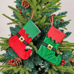 Festive red and green elf boots Christmas stockings with gold bells on a Christmas tree
