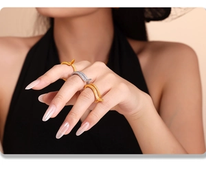 Detail shot of three snake rings in gold and silver finish worn by a fashion model