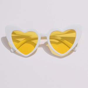Top-down view of heart-shaped sunglasses with white frames and transparent yellow lenses
