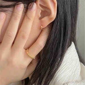 Close-up of minimalist gold heart ring and hoop earring set on a model for daily styling