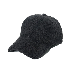 Detail of black sherpa fleece baseball cap showing textured plush fabric and curved brim