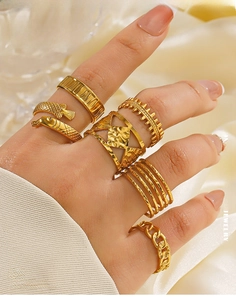 Detail of 6-piece stackable gold stainless steel rings with geometric and fish motifs