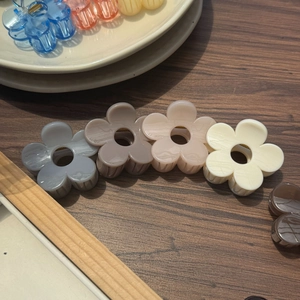 Barrettes à cheveux fleurs 5cm élégantes en couleurs pastel sur une table en bois
