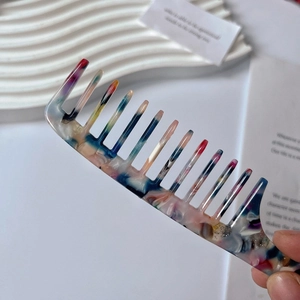 Detailed close-up of wide-tooth acetate comb with colorful marble pattern finish