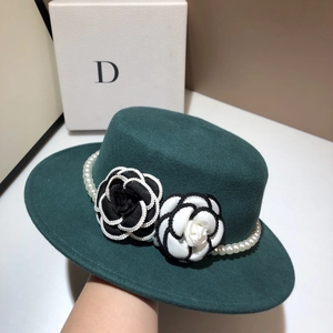 Close-up of wool fedora with handmade camellia flowers and elegant pearl chain trim