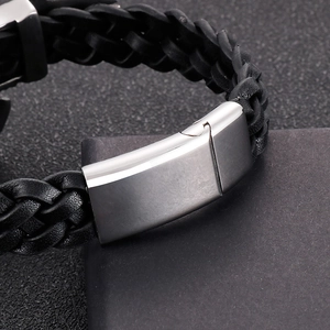 Detail shot of the braided leather texture and brushed stainless steel clasp on the bracelet