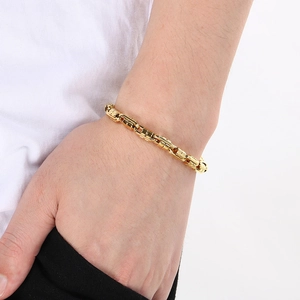 Close-up of golden stainless steel Byzantine chain bracelet worn on a wrist