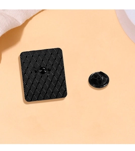 Detailed back view of square metal brooch with black plating and textured non-slip grid