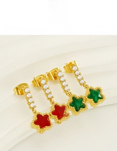 Détail de boucles d'oreilles étoile en acier titane avec gemmes et perles alignées