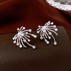 Macro detail of silver firework earrings with white pearls and sparkling zircons