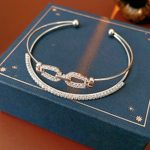 Détail macro du bracelet double couche en argent avec zircons sur un écrin bleu élégant