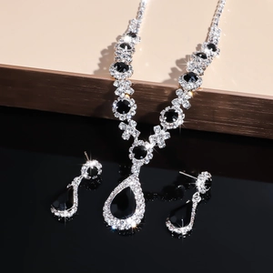 Detailed view of pear-cut black crystal necklace and earrings set with silver accents