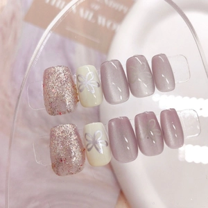 Macro detail of cat-eye press-on nails with silver flowers and glitter in 10-piece set