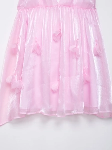 Detail van roze zomerjurk met 3D-bloembladen en glinsterende metallic textuur