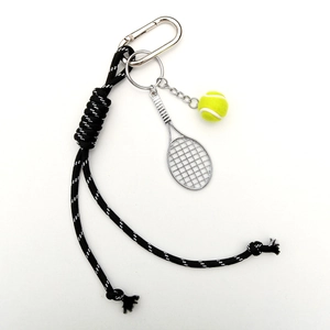 Detailed shot of a tennis racket keychain with a mini ball and braided nylon cord