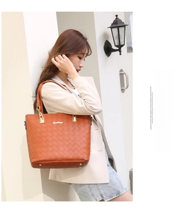 Detail of orange woven tote bag showing premium texture and metallic brand plaque