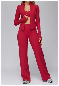 Detail of high-waist flared yoga pants and thumbhole cuffs on a dark red sportswear set