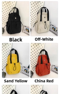 Detail view of small nylon drawstring backpacks in black, beige, yellow, and red colors