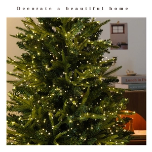Detail showing festive LED string lights on a green Christmas tree in a warm indoor setting