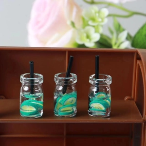 Detailed macro view of three miniature lemon drink bottles with straws and fruit slices