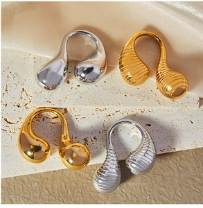 Detail of gold and silver teardrop open rings with smooth and textured finishes on stone