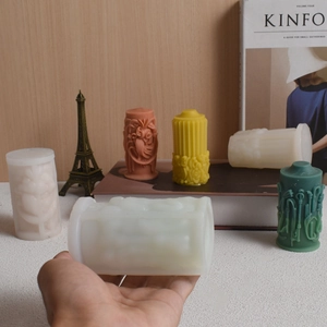 Detailed white silicone mold and finished column candles with floral relief patterns