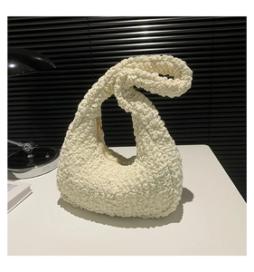 Detail of off-white cloud pleat bag showing textured popcorn fabric and gold zipper