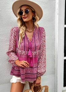 Detail of pink bohemian blouse featuring intricate print patterns and tassel neck ties