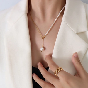 Detail of French vintage 18k gold plated choker with baroque pearl pendant and chain ring
