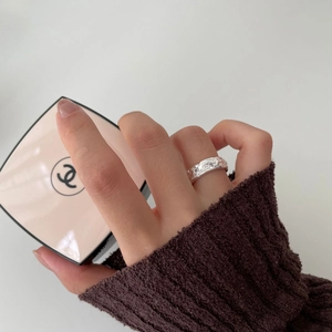 Detail of 925 sterling silver ring with irregular moon surface texture on model finger
