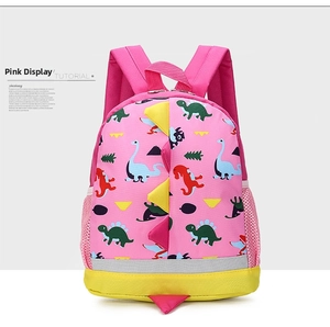 Detail of pink dinosaur backpack showing side mesh pocket and gray reflective safety strip