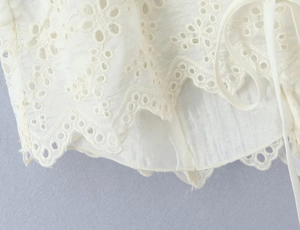 Detailed close-up showing the intricate white lace trim and cotton texture of the camisole