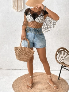 Détail de haut de plage noir en maille bohème avec franges de perles dorées et glands