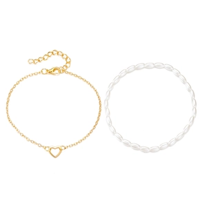 Fashionable pearl bead bracelet set with hollow heart charm on a golden chain