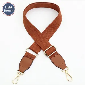 Adjustable light brown canvas shoulder strap with golden metal lobster clasps for bags