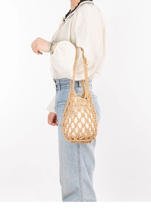 Detail of handmade hollow woven beach bag with white inner pouch and cotton rope texture