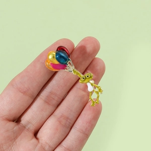 Détail d'un pin's grenouille mignonne en émail avec des ballons multicolores
