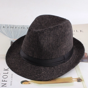 Détail d'un fedora à carreaux marron avec ruban noir sur un magazine Kinfolk élégant
