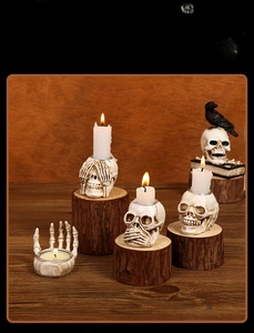Gothic resin skull candle holders and bone hand stand on rustic wood for Halloween