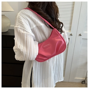 Détail du sac sous le bras rose avec fond plissé et étiquette logo de mode