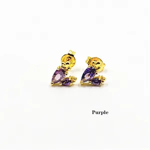 Detail of elegant gold earrings featuring pear-cut purple gemstones and small zircon accents